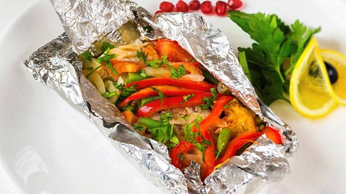 Pescado y verduras cocidos en papel de aluminio